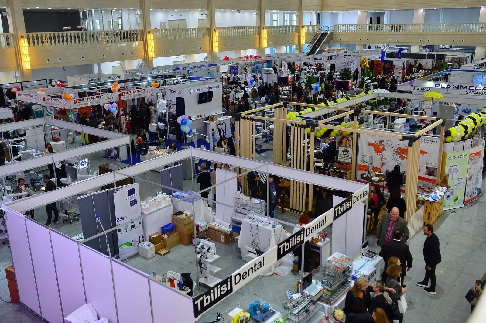 GDDA EXPO 2025-ის საგამოფენო დარბაზი, სავსე სტომატოლოგიური აღჭურვილობის სტენდებითა და სტუმრებით